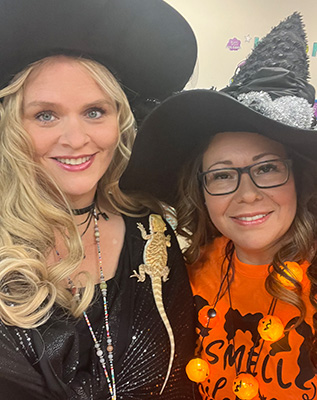 Two ladies dressed as Halloween witches